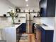Modern kitchen features navy cabinets, stainless steel appliances, granite countertops, and stylish open shelving at 95 Mccoy Dr, Carrollton, GA 30116