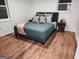 A cozy bedroom with hardwood floors, two windows, a queen bed and two end tables at 95 Mccoy Dr, Carrollton, GA 30116
