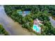 Aerial view showcases tennis courts, a swimming pool, a clubhouse, and lush greenery by the river at 130 Floss Flower Ct, Roswell, GA 30076