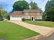 Charming two-story brick home with a manicured lawn and an attached two-car garage at 130 Floss Flower Ct, Roswell, GA 30076