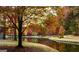 Scenic lake view showcasing vibrant fall foliage, a peaceful setting, and walking path at 130 Floss Flower Ct, Roswell, GA 30076