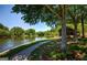 Scenic lake view with walking path, mature trees, and grassy area on a sunny day at 130 Floss Flower Ct, Roswell, GA 30076