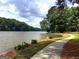 Scenic lake view with a paved pathway, trees and a serene setting at 130 Floss Flower Ct, Roswell, GA 30076