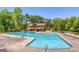 Large community pool surrounded by sun loungers, greenery, and a two-story building with balconies at 130 Floss Flower Ct, Roswell, GA 30076