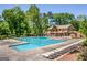 Large community pool surrounded by sun loungers, greenery, and a two-story building with balconies at 130 Floss Flower Ct, Roswell, GA 30076
