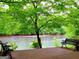 Relaxing river view from a wooden deck with benches under lush trees, perfect for enjoying nature at 130 Floss Flower Ct, Roswell, GA 30076