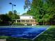 Community tennis courts next to clubhouse with a covered deck and wooded surroundings at 130 Floss Flower Ct, Roswell, GA 30076
