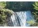 Scenic waterfall surrounded by lush greenery, showcasing a natural and serene water feature at 130 Floss Flower Ct, Roswell, GA 30076