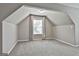 Cozy attic room features angled ceilings, a window with blinds, and neutral paint at 70 Pacific Ave, Sharpsburg, GA 30277