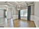 Open-concept dining area featuring hardwood floors, coffered ceilings, designer light fixture, and adjacent living space at 70 Pacific Ave, Sharpsburg, GA 30277