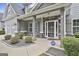 Charming covered porch with stone accents, gray columns, and tasteful landscaping create curb appeal at 70 Pacific Ave, Sharpsburg, GA 30277