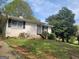 Charming single-story home featuring a brick facade, mature trees, and a cozy entrance, perfect for comfortable living at 7588 Covington Hwy, Lithonia, GA 30058
