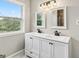 Bright bathroom featuring a double vanity with modern fixtures and a window with a view at 2955 Peeksville Rd, Locust Grove, GA 30248