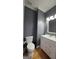 This bathroom has a white toilet and white vanity with gray walls and a light above the mirror at 303 Sedgewick Trl, Lawrenceville, GA 30044