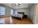 Main bedroom featuring hardwood floors, trey ceiling, and a patterned comforter set at 303 Sedgewick Trl, Lawrenceville, GA 30044