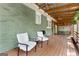 Spacious covered back porch with wooden flooring and ceiling fans, perfect for outdoor relaxation at 2364 Woodside Way, Atlanta, GA 30341