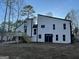 Back exterior showing deck, dual door access, and windows in a wooded lot at 783 Lost Creek Cir, Stone Mountain, GA 30088
