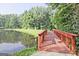 A charming wooden bridge spans the water, enhancing the serene waterfront property at 783 Lost Creek Cir, Stone Mountain, GA 30088