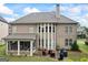 Exterior view of home featuring screened porch, stone patio, and multi-paneled windows at 4769 Moon Hollow Ct, Buford, GA 30519