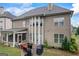 Exterior view of a home showcasing a screened porch, stone patio, and beautifully designed windows at 4769 Moon Hollow Ct, Buford, GA 30519