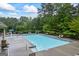 Community pool with lounge chairs and tables surrounded by lush trees at 4769 Moon Hollow Ct, Buford, GA 30519
