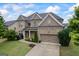 Charming brick home featuring a manicured lawn, two-car garage, and welcoming front porch at 4769 Moon Hollow Ct, Buford, GA 30519