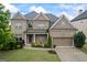 Stunning brick home featuring a manicured lawn, two-car garage, and welcoming front porch at 4769 Moon Hollow Ct, Buford, GA 30519