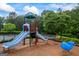 Community playground with slides and a whale spring rider surrounded by mulch and trees at 4769 Moon Hollow Ct, Buford, GA 30519
