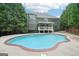 View of the backyard with swimming pool and two story home with lots of windows at 1979 Alcovy Shoals Blf, Lawrenceville, GA 30045