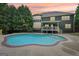 View of the backyard with swimming pool and two story home with lots of windows at sunset at 1979 Alcovy Shoals Blf, Lawrenceville, GA 30045