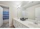 Bright bathroom with double sinks, a large mirror, and a shower/tub with blue striped curtain at 1979 Alcovy Shoals Blf, Lawrenceville, GA 30045