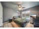Gray bedroom with wood floors, a ceiling fan, large window, and a black leather bed frame at 1979 Alcovy Shoals Blf, Lawrenceville, GA 30045