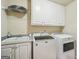 Bright laundry room with white cabinets, sink, and modern washer and dryer units at 1979 Alcovy Shoals Blf, Lawrenceville, GA 30045