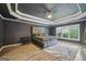 Elegant main bedroom with tray ceiling, wood-look floors, and abundant natural light from windows at 1979 Alcovy Shoals Blf, Lawrenceville, GA 30045