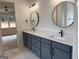 Bathroom with gray cabinetry, double sinks, and two round mirrors at 555 Discovery Lake Dr, Fayetteville, GA 30215