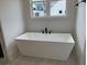 Freestanding bathtub with elegant fixtures set beneath a window at 555 Discovery Lake Dr, Fayetteville, GA 30215