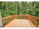 View of a stained wood deck overlooking lush trees in backyard at 5582 Rockingwood Ct, Atlanta, GA 30349