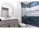 Modern bathroom with black finishes featuring a glass shower and vanity with arched mirror at 5582 Rockingwood Ct, Atlanta, GA 30349