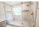 Tiled shower featuring frameless glass, a built-in bench, and modern bronze fixtures at 5582 Rockingwood Ct, Atlanta, GA 30349
