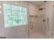 Spacious shower featuring glass doors, bench, rain shower head, and tile surround at 5582 Rockingwood Ct, Atlanta, GA 30349