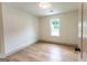 Bright bedroom with a window letting in natural light and neutral walls with wood floors at 5582 Rockingwood Ct, Atlanta, GA 30349