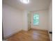 Cozy bedroom with a window overlooking greenery and featuring light hardwood flooring and neutral walls at 5582 Rockingwood Ct, Atlanta, GA 30349