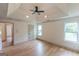 Spacious bedroom with tray ceiling, fan, light wood floors, and windows for natural light at 5582 Rockingwood Ct, Atlanta, GA 30349