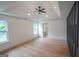 Large bedroom featuring tray ceiling, fan, wood floors, and two windows with natural light at 5582 Rockingwood Ct, Atlanta, GA 30349