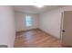 Light-filled bedroom with hardwood floors and a window offering views of the surrounding greenery at 5582 Rockingwood Ct, Atlanta, GA 30349