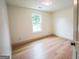 Bright bedroom features light hardwood floors, neutral walls, and natural light from a window at 5582 Rockingwood Ct, Atlanta, GA 30349