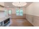 Bright dining area with chandelier, wainscoting, and view to a wooded lot at 5582 Rockingwood Ct, Atlanta, GA 30349