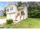 Charming two-story home with a two-car garage and inviting entrance with wood and black trimmed steps at 5582 Rockingwood Ct, Atlanta, GA 30349