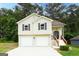 Charming two-story home with a two-car garage and well-maintained front yard and inviting wood and black trimmed entrance at 5582 Rockingwood Ct, Atlanta, GA 30349