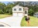 Charming two-story home with a two-car garage and long driveway on a sunny day at 5582 Rockingwood Ct, Atlanta, GA 30349